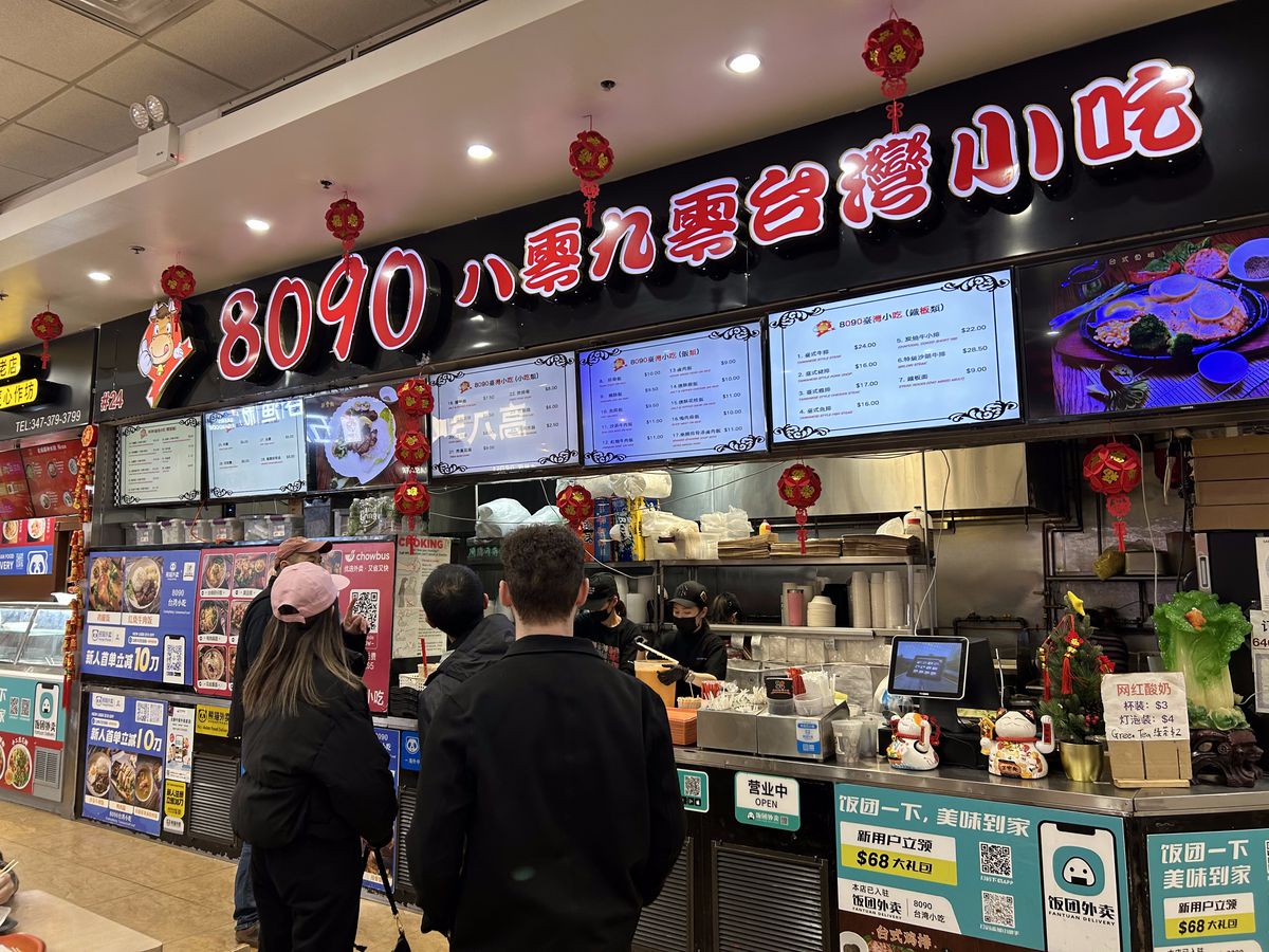 Customers consider the options listed on a digital display at 8090 Taiwain in the New York Food Court.