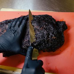 After 12-14 hours in the smoker, Dallman prepares to trim the burnt-crisp points away from the brisket.