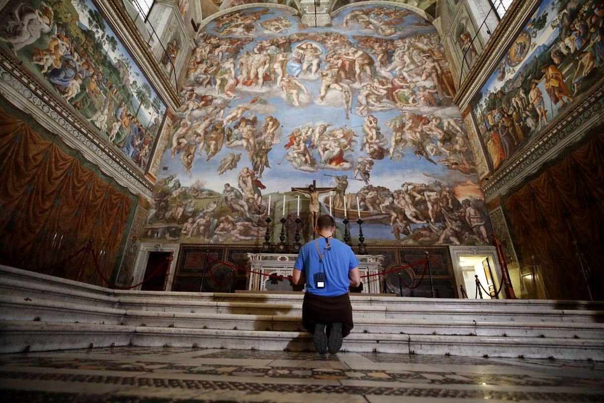 A visitor kneels in front of the Last Judgement fresco by the Italian Renaissance painter Michelangelo inside the Sistine Chapel of the Vatican Museums on the occasion of the museum’s reopening, in Rome, Monday, May 3, 2021. 
