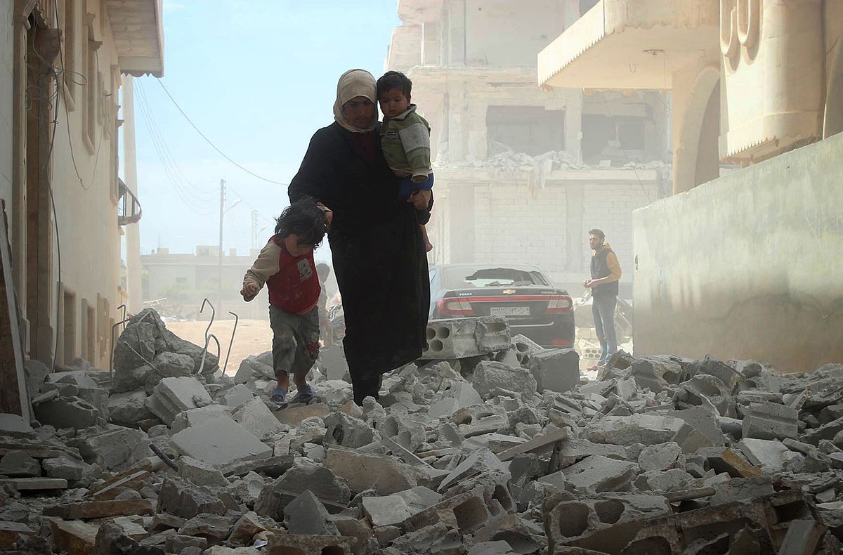 Syrian family walks through the rubble of Idlib, in northwestern Syria (Umit Erdogan/Anadolu Agency/Getty)