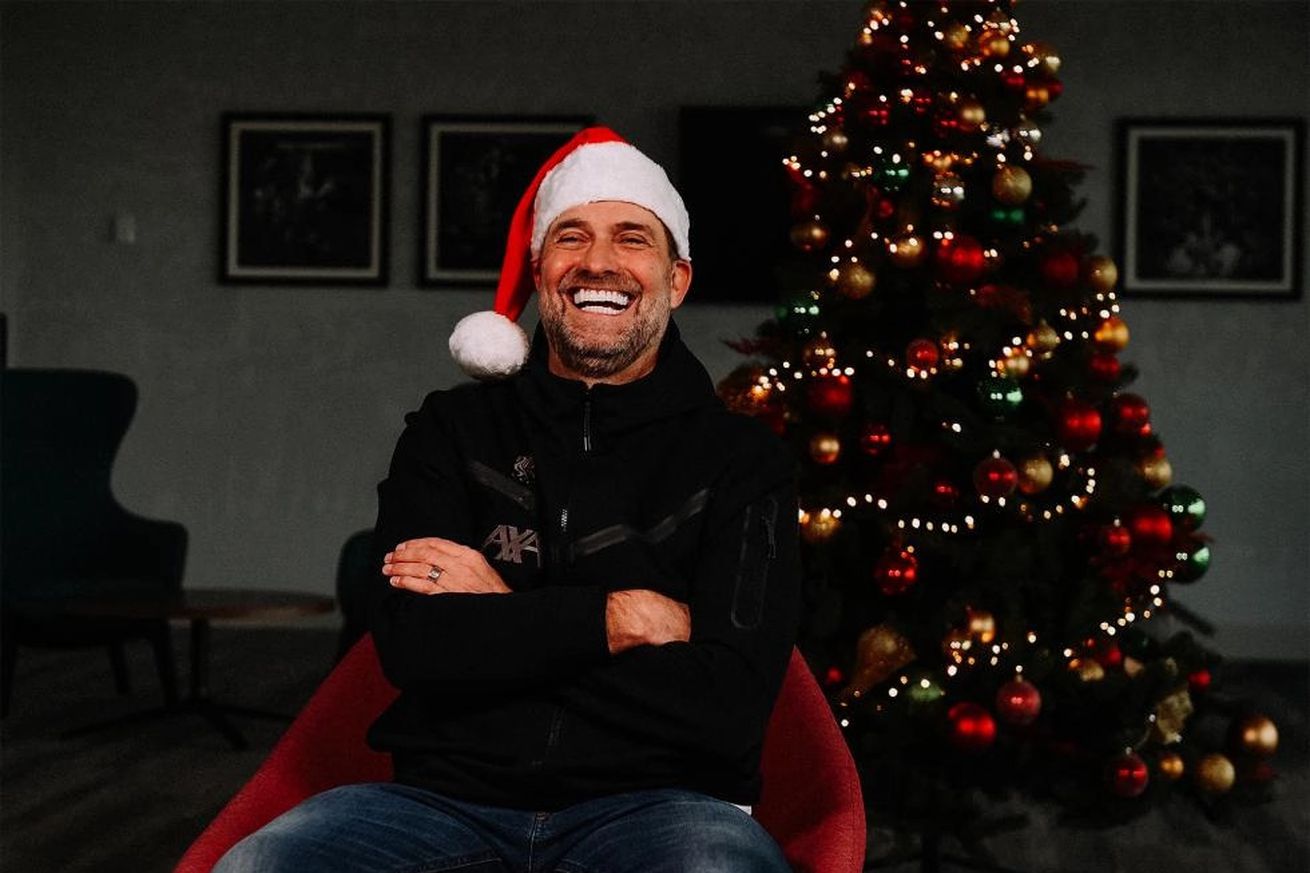 Jürgen Klopp sitting in front of a Christmas tree with a Santa hat on