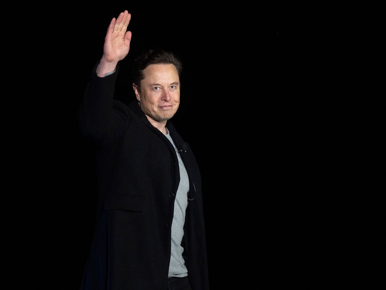 Elon Musk standing and waving.