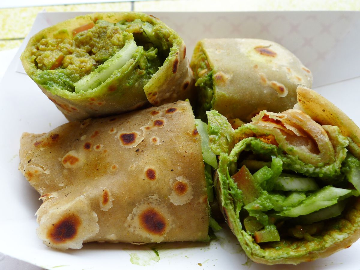 A roti roll from Bombay Frankie cut into three pieces to show its vegetable laden interior.