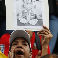 An anti-government demonstrator holds a cartoon of the president of the National Electoral Center, Tibisay Lucena, that reads in Spanish "The polls don't matter when fraud is irreversible," during a vigil in honor of those who have been killed during clashes between security forces and demonstrators in Caracas, Venezuela, Monday, July 31, 2017. Many analysts believe Sunday's vote for a newly elected assembly that will rewrite Venezuela’s constitution will catalyze yet more disturbances in a country that has seen four months of street protests in which at least 125 people have died. (AP Photo/Ariana Cubillos)