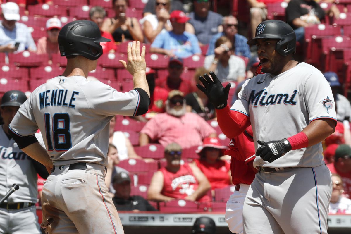 Miami Marlins designated hitter Jesus Aguilar (99) reacts with third baseman Joey Wendle (18) after hitting a two-run home run against the Cincinnati Reds during the third inning at Great American Ball Park.