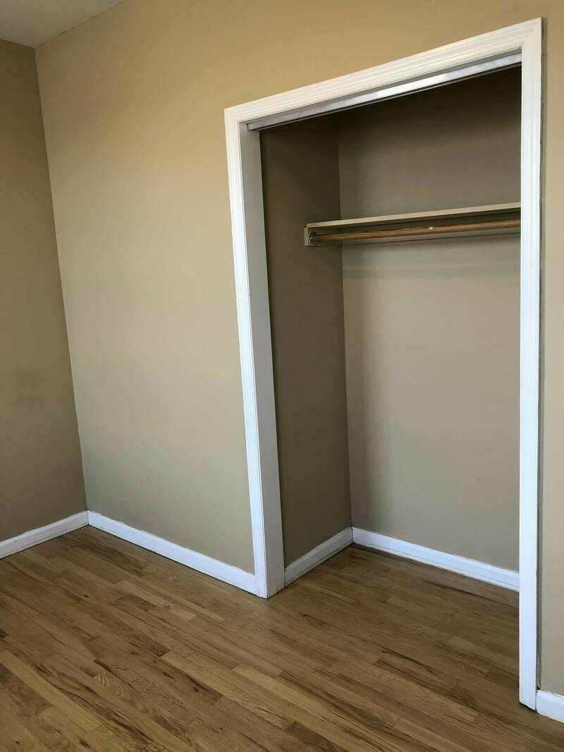 A closet inside a bedroom with beige walls.