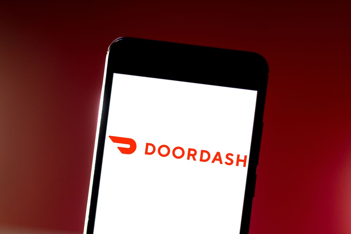 In this photo illustration the DoorDash logo is seen...