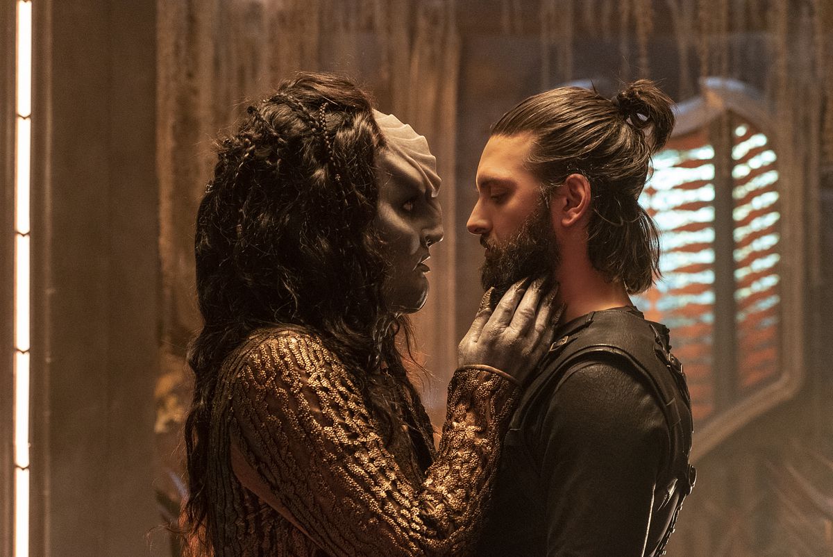 L’Rell (Mary Chieffo) leaning into kiss someone in a still from Star Trek Discovery season 2. She now has a more regular (but still big) shaped head and long black hair with braids.