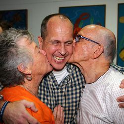 Australian journalist Peter Greste is hugged by his mother Lois, left, and father Juris, right, after his arrival in Brisbane, Australia, Thursday, Feb. 5, 2015. Greste, a reporter for Al-Jazeera English was released from an Egyptian prison and deported after more than a year behind bars. 