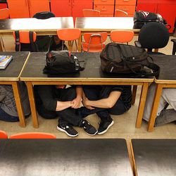 Taylorsville High School students in Steve Woolley's physics class crawl under their desks as they participate in an earthquake drill as part of The Great Utah ShakeOut, Tuesday, April 17, 2012.