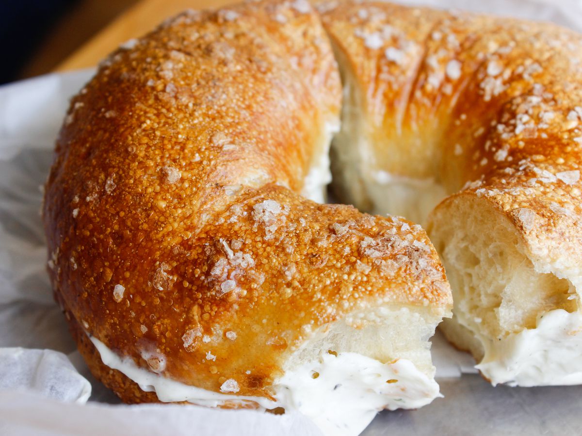 A close-up of a bagel with cream cheese, sliced in half