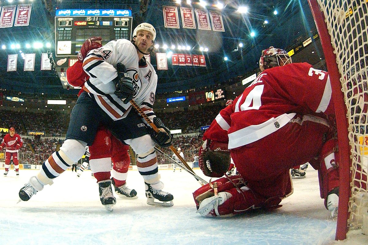 Ryan Smyth of the Edmonton Oilers battles for position behind Manny Legace of the Detroit Red Wings in game two of the Western Conference Quarterfinals during the 2006 NHL Playoffs on April 23, 2006 at Joe Louis Arena.