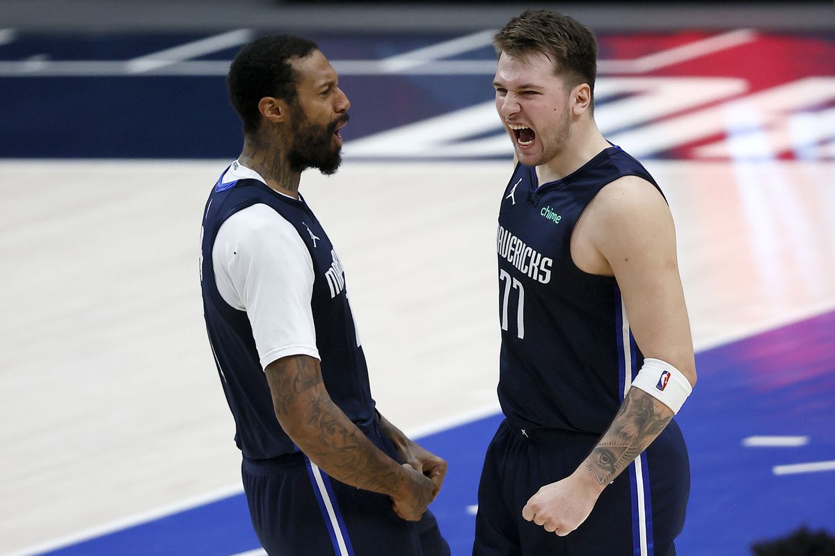 Luka Doncic of the Dallas Mavericks celebrates with James Johnson of the Dallas Mavericks after making the game-winning shot against the Boston Celtics at American Airlines Center on February 23, 2021 in Dallas, Texas.