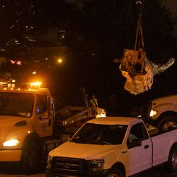 A crane moves the Christopher Columbus Statue to a waiting flatbed truck in Grant Park, Friday, July 24, 2020.