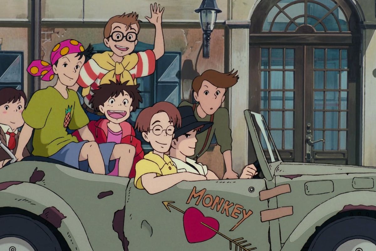 Tombo waves as he and his friends ride up in their busted-ass convertible in Kiki’s Delivery Service. 