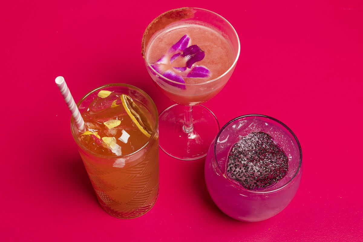 Three colorful cocktails on a pink background.