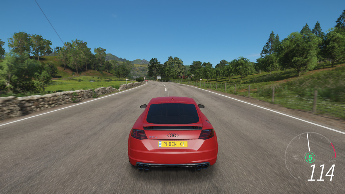 A red car races down a paved road in Forza Horizon 4
