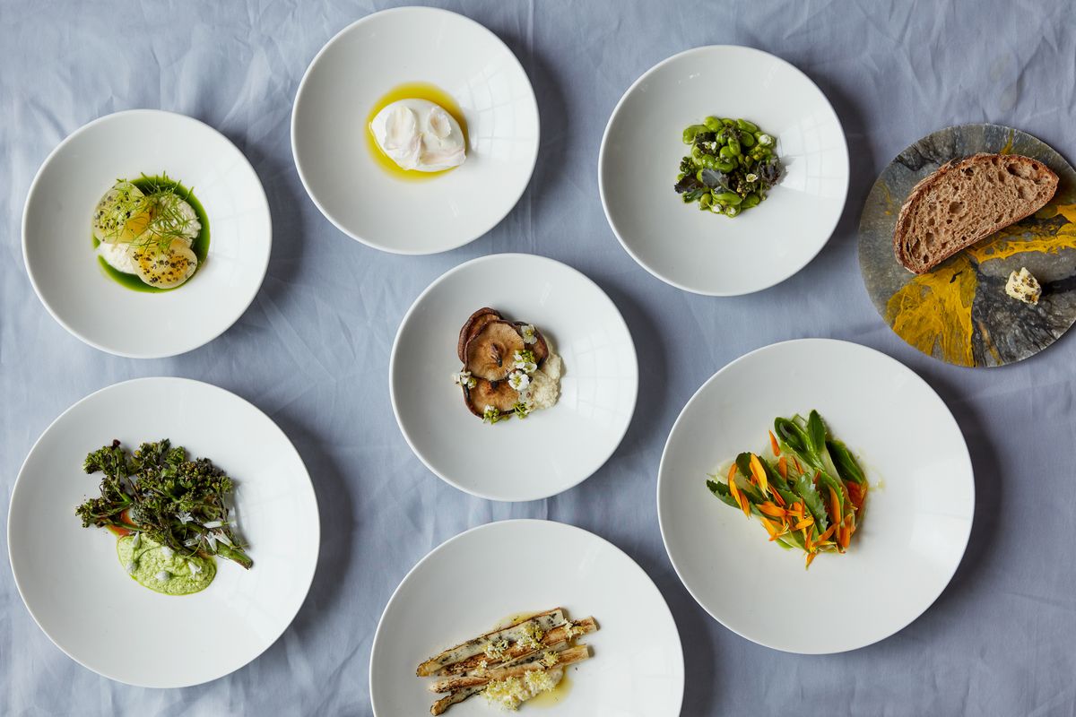 A spread of dishes on white plates and a blue tablecloth at Silo London