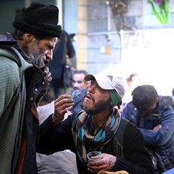 In this Tuesday, Feb. 3, 2015 photo, a drug addict smokes cigarette at a drop-in center and shelter, south of Tehran, Iran. Anti-narcotics and medical officials say more than 2.2 million of Iran's 80 million citizens already are addicted to illegal drugs, including 1.3 million on registered treatment programs. 
