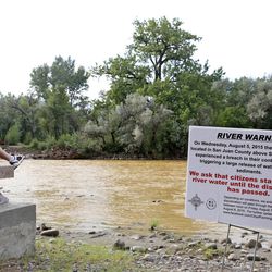 A warning sign from the city is displayed in front of the Animas River as orange sludge from a mine spill upstream flows past Berg Park in Farmington, N.M., Saturday, Aug. 8, 2015. About 1 million gallons of wastewater from Colorado's Gold King Mine began spilling into the Animas River on Wednesday when a cleanup crew supervised by the Environmental Protection Agency accidentally breached a debris dam that had formed inside the mine. The mine has been inactive since 1923. 