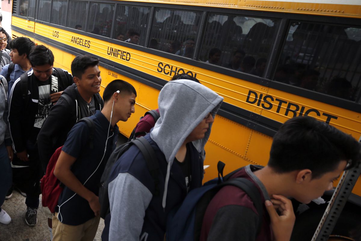 Students line up for a school bus on the first day of school in Los Angeles this year.