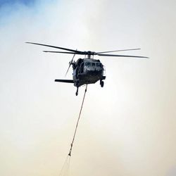 A helicopter from Ft. Carson's 4th Combat Aviation Brigade heads back for another load of water as the Black Forest Fire burns out of control for a second straight day near Colorado Springs, Colo. on Wednesday, June 12, 2013. Three Colorado wildfires fueled by hot temperatures, gusty winds and thick, bone-dry forests have together burned dozens of homes and led to the evacuation of more than 7,000 residents and nearly 1,000 inmates at medium-security prison. 