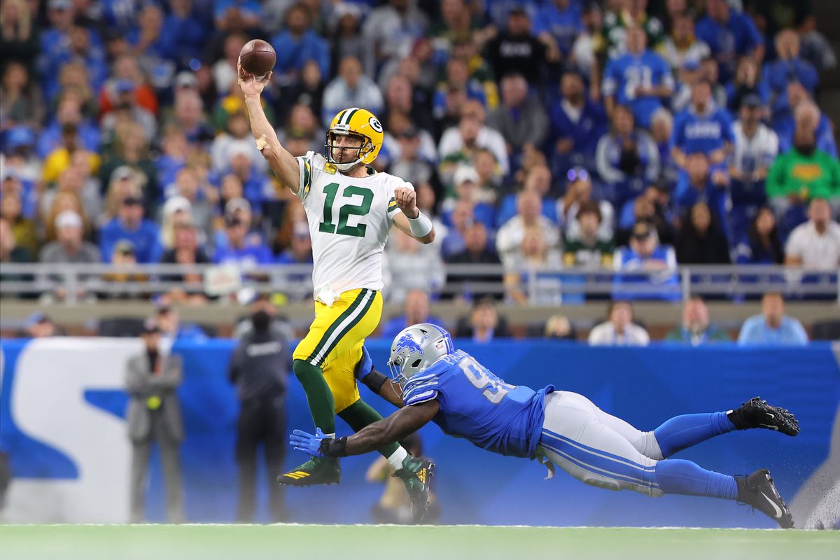Aaron Rodgers of the Green Bay Packers throws a pass in the fourth quarter as Josh Paschal #93 of the Detroit Lions dives for a tackle at Ford Field on November 06, 2022 in Detroit, Michigan.