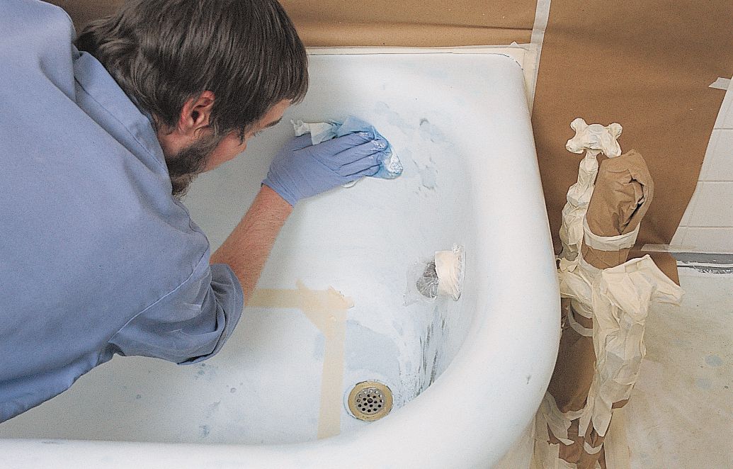 <p>Before spraying, Ayers applies a blue bonding agent over the tub's entire surface, a necessary step to ensure that the new finish won't peel off the old porcelain.</p>