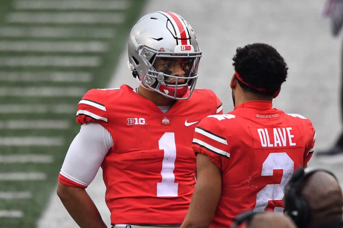 Quarterback Justin Fields of the Ohio State Buckeyes talks with receiver Chris Olave of the Ohio State Buckeyes during a game against the Indiana Hoosiers at Ohio Stadium on November 21, 2020 in Columbus, Ohio.