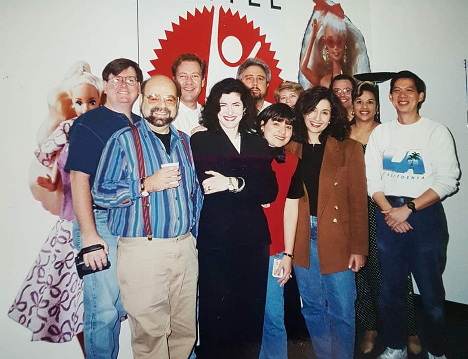 A group photo of the Mattel Media team. There are cutouts of Barbie in the background