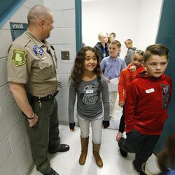 Third-grade students from Kaysville's Endeavor Elementary look over the holding room at the Farmington Courthouse on Tuesday, March 22, 2016. The students were at the courthouse to conduct a mock trial with 2nd District Court Judge Thomas Kay. The trial focused on the case of Big Bad Wolf vs. Curley the Pig. Big Bad Wolf was acquitted. Utah State Court judges are encouraged to take an active part in the community to increase public understanding and promote public confidence in the judiciary. As part of this effort, Kay conducted the mock trial with students playing prosecuting and defense attorneys, witnesses, victims, the defendant, jurors, and courtroom personnel.