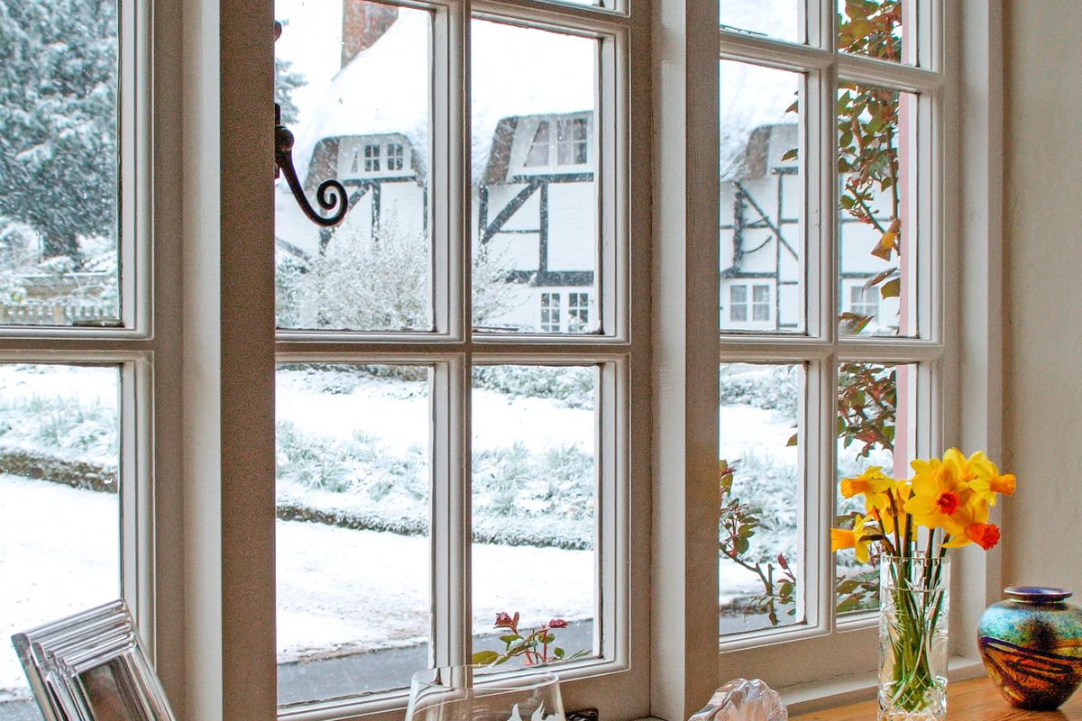 White framed windows with view of snow outside.