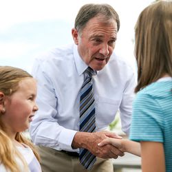 Gov. Gary Herbert chats with sisters Jetta Jenkins, 4, left, and Kali Jenkins, 8, right, of North Ogden, during an event at Burger Bar in Roy on Tuesday, June 7, 2016. Herbert visited the restaurant to read a proclamation honoring its founder, Ben Fowler, who recently died at 96, and to campaign for re-election.