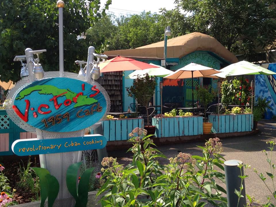 A sunny garden with a sign for the restaurant