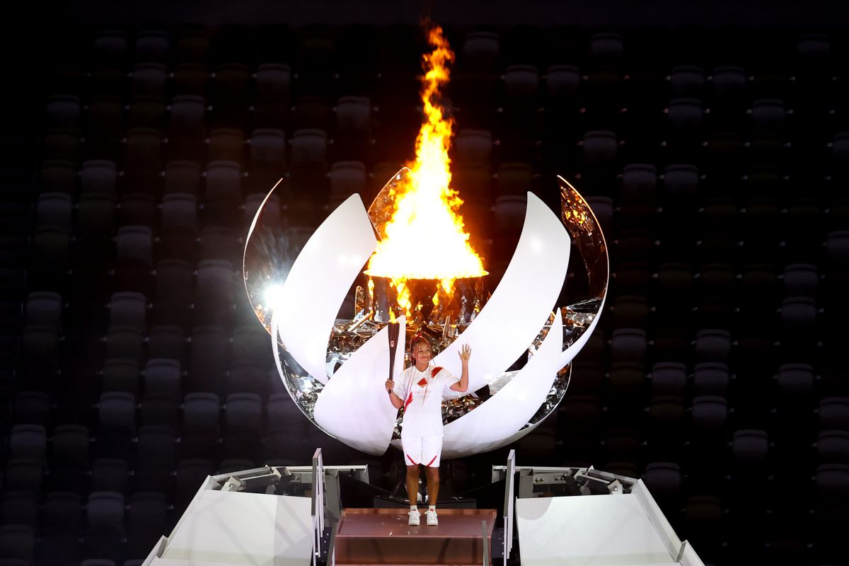 Naomi Osaka of Japan stands with the Olympic flame during the Opening Ceremony of the Tokyo 2020 Olympic Games at Olympic Stadium on July 23, 2021 in Tokyo, Japan.