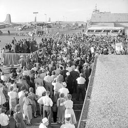 Crowd gathers at the airport to welcome presidential candidate Sen. John F. Kennedy to Salt Lake City in 1960 and listen to his remarks.