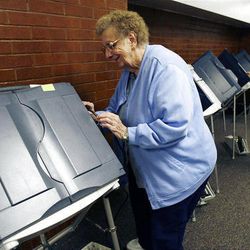 Beverly Noorda, left and Malinda Bills set up voting machines at Sandy Elementary School in Sandy, Monday, Nov. 7, 2011.