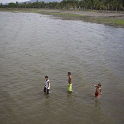 Youths wade through Cocibolca Lake in Granada, Nicaragua, Friday. A concession to build a canal across Nicaragua linking the Pacific Ocean and Caribbean Sea, which would go through this lake, will be awarded to a Chinese company.