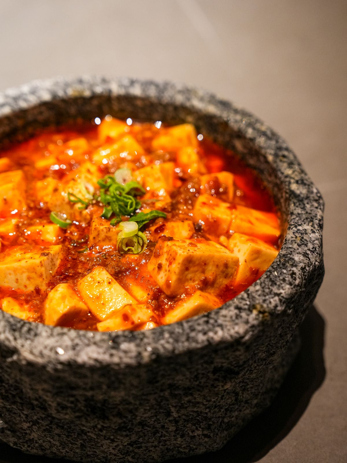 Mapo tofu in a textured black bowl.
