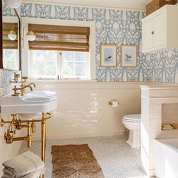 The children’s bath was gutted but the layout  preserved, saving time and money. Plumbing lines  under the sink are unlacquered brass to echo the legs supporting the console sinks.
