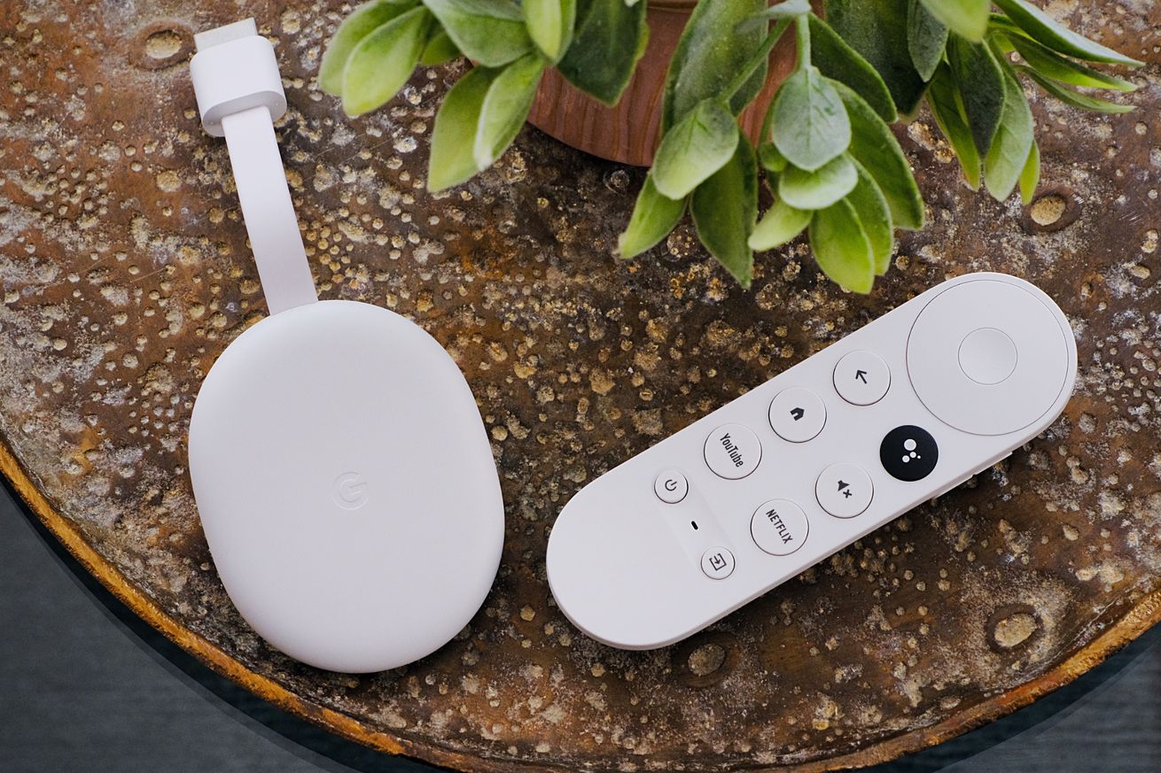 An image of the Chromecast with Google TV HD and its remote control next to a plant.