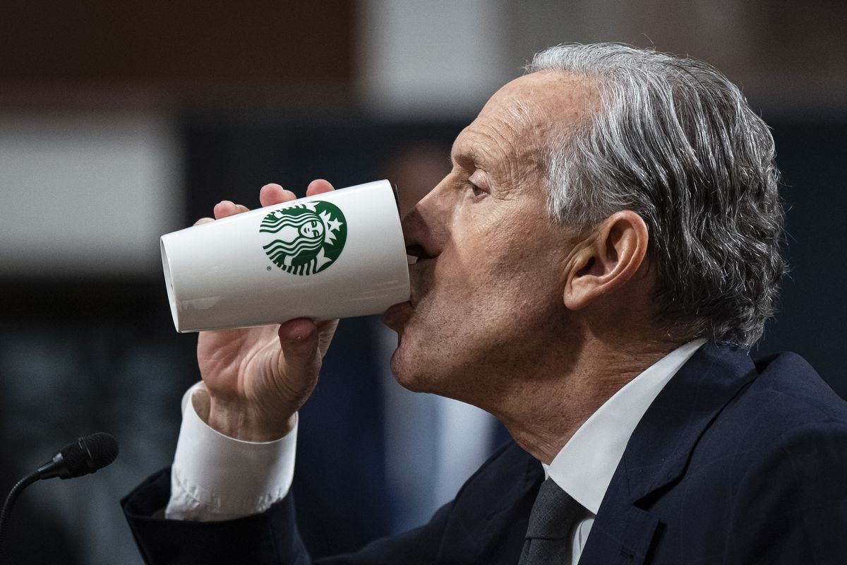 Howard Schultz drinks from a Starbucks cup