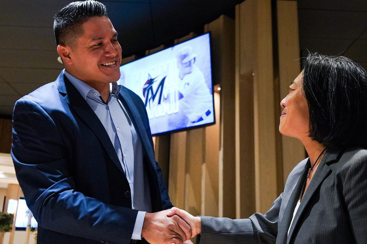 Avisail Garcia shakes hands with general manager Kim Ng after officially signing with the Miami Marlins