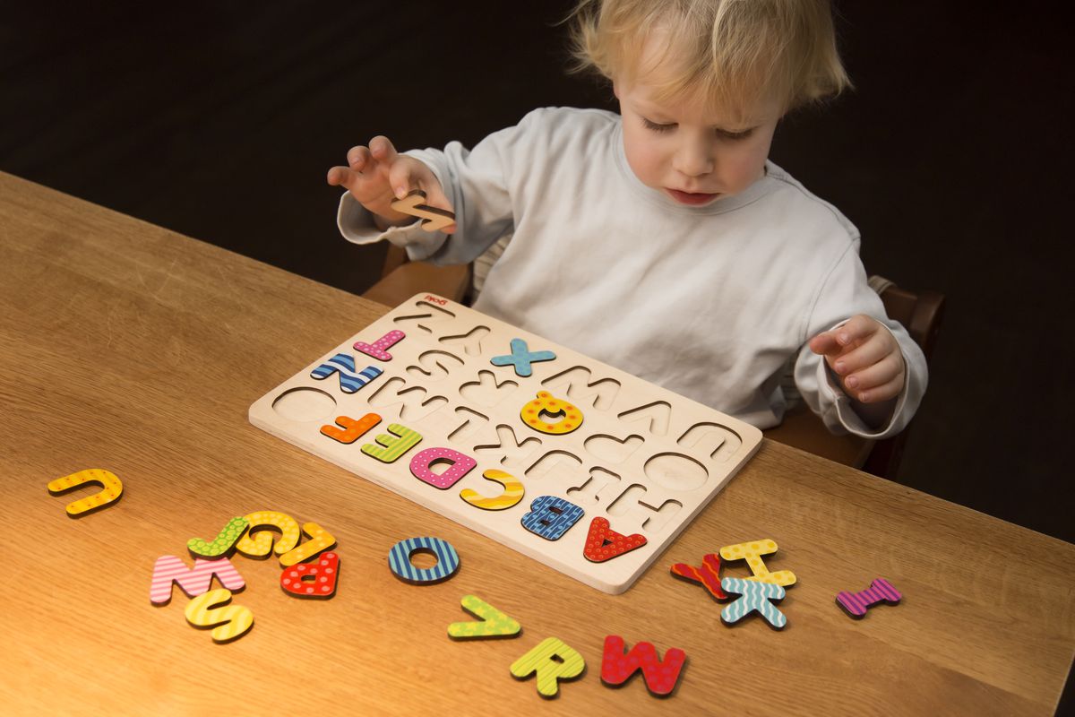 Boy, 2 years old, playing with an ABC puzzle