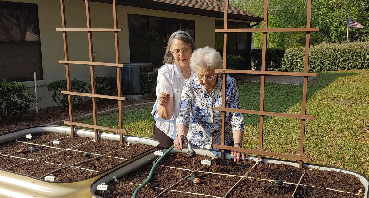 Brenda Flowers (left) and 96-year-old Lorraine Tyree, water their plants in Crystal River, Florida. Backyard gardeners are coming together, mostly virtually, to learn and share stories on how to grow vegetables, fruits and flowers as the novel coronavirus raises fears about disruptions in food supplies and the cost of food in a down economy.