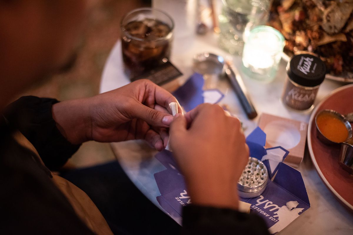 An Original Cannabis Cafe customer rolling a joint at the U.S.’s first cannabis restaurant.