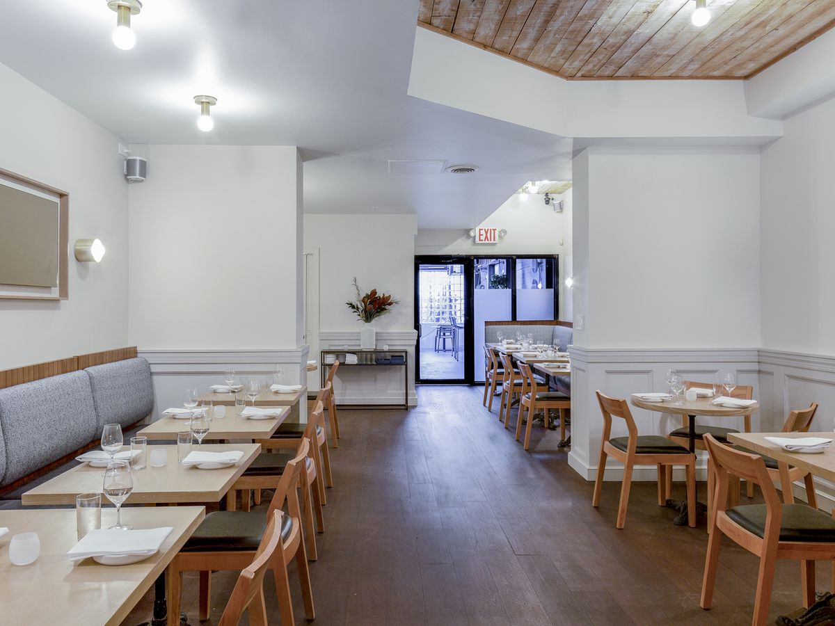 A very white dining room at Prospect Heights restaurant Oxalis, outfitted with tables set for service.