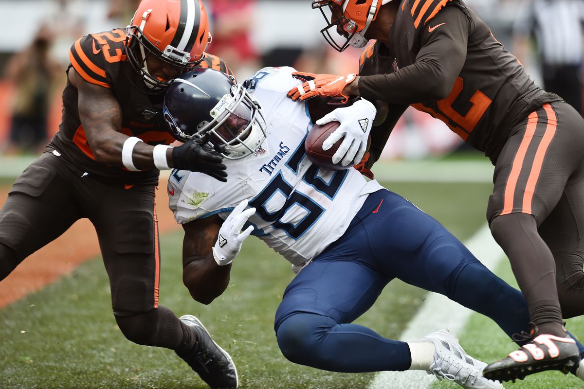 Tennessee Titans tight end Delanie Walker scores a touchdown as Cleveland Browns strong safety Damarious Randall and strong safety Morgan Burnett defend during the second half at FirstEnergy Stadium.