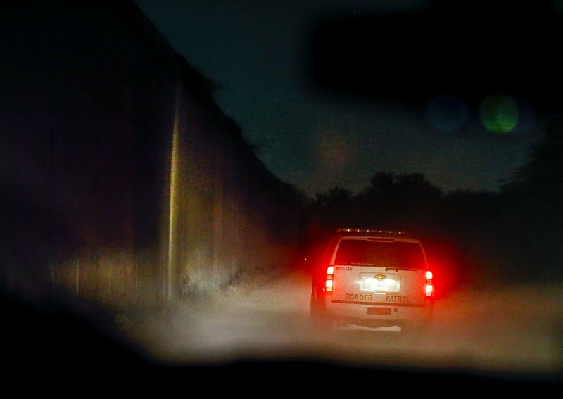 A Border Patrol agent drives along the border wall near McAllen, Texas, on Tuesday, June 22, 2021.