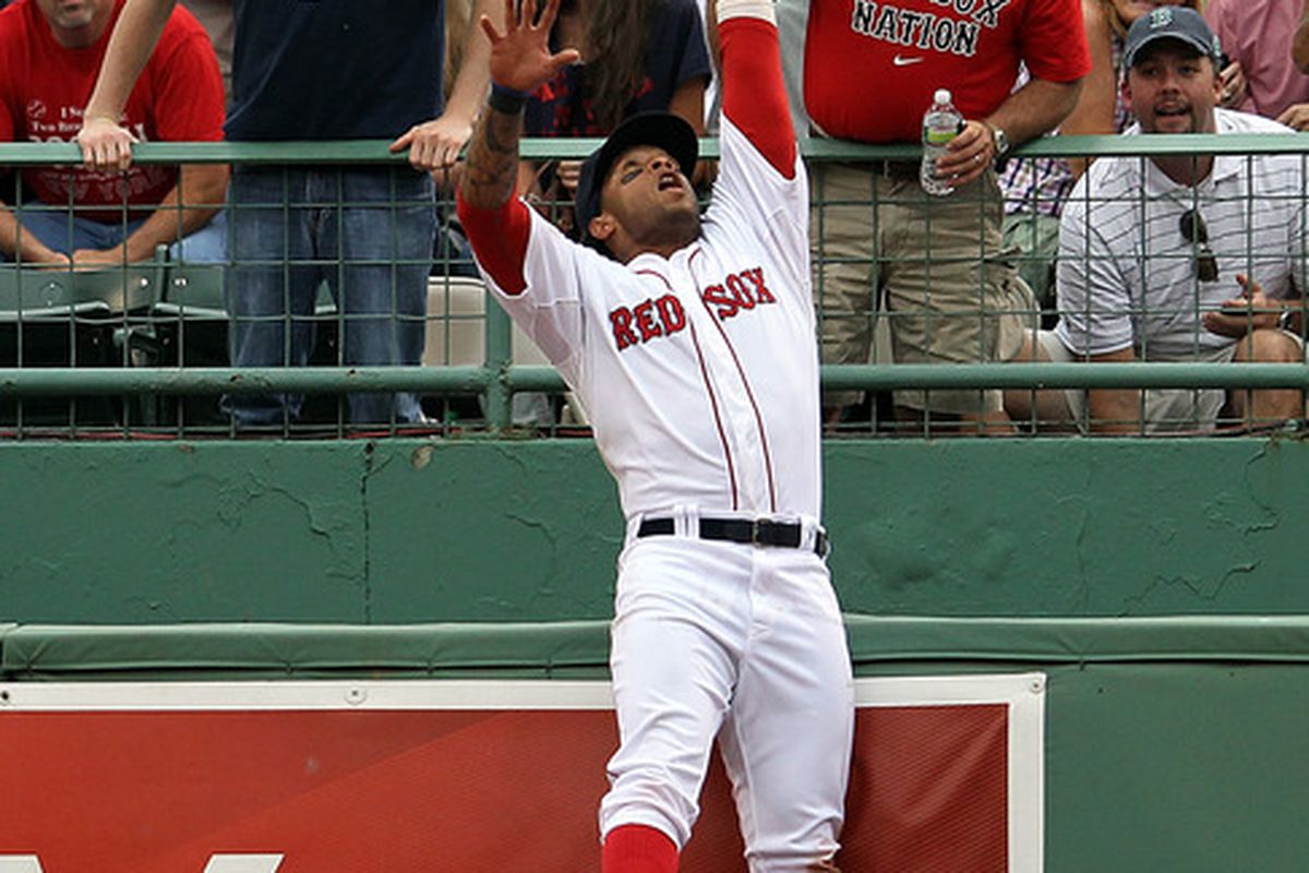 BOSTON, MA -  Darnell McDonald #54 of the Boston Red Sox leaps to make a catch from a ball hit by Kelly Johnson #2 of the Toronto Blue Jays in the ninth inning at Fenway Park in Boston, Massachusetts.  (Photo by Jim Rogash/Getty Images)